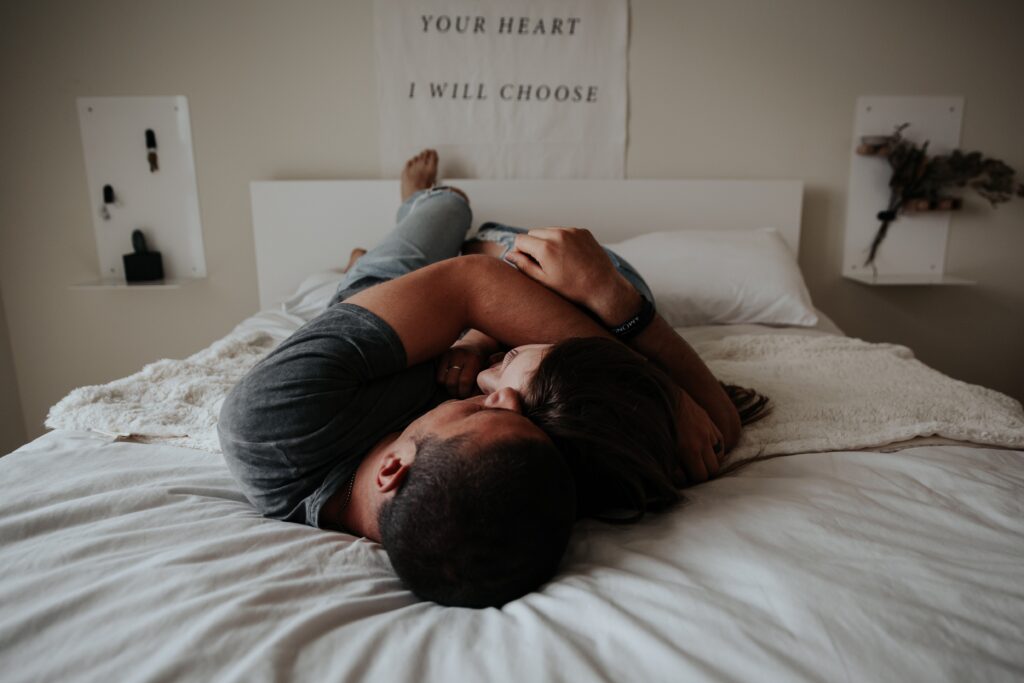 man and woman cuddling in bed